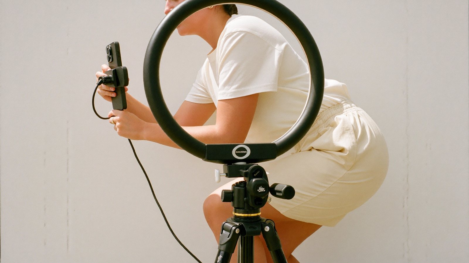 A freelance model setting up a phone on a tripod to shoot her own content